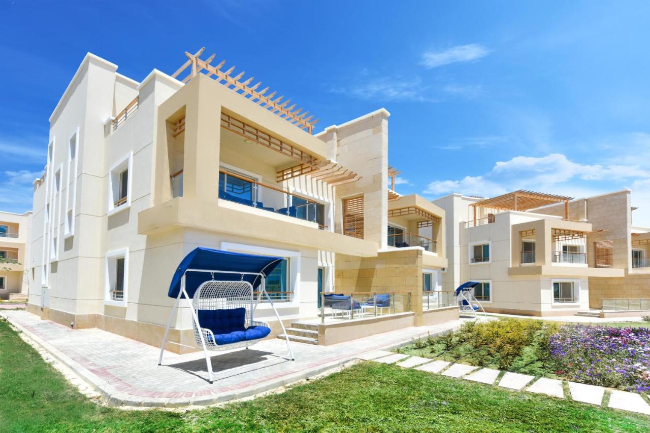 Tolip Resort El Galala Majestic Ain Sukhna Dış mekan fotoğraf The photo displays a modern residential complex featuring two or more white buildings with a contemporary architectural design. Each building has balconies, large windows, and a sunshine-friendly layout that maximizes natural light. In the foreground
